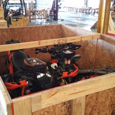 Two motorbikes packed together inside one open crate