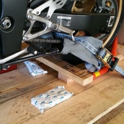 Close-up of a rear wheel strap and silica gel packets in a crate