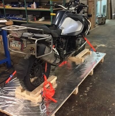 BMW GS adventure bike strapped on a wooden pallet, rear view