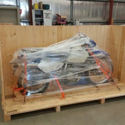 Suzuki motorbike wrapped in plastic film in a crate