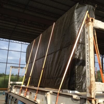 Tarp-wrapped cargo strapped to a flatbed trailer
