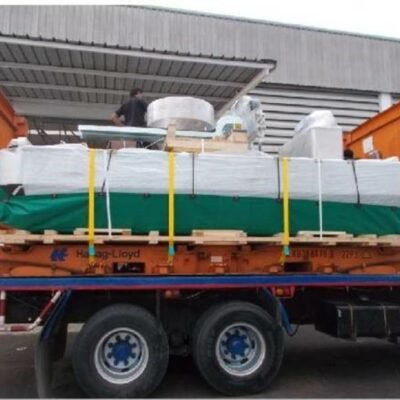 Tarp-wrapped cargo strapped on a flatbed trailer